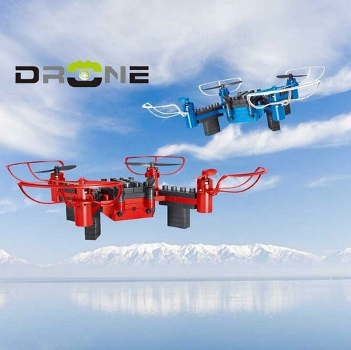 Two drones, one red and one blue, flying against a sky with clouds and mountains.