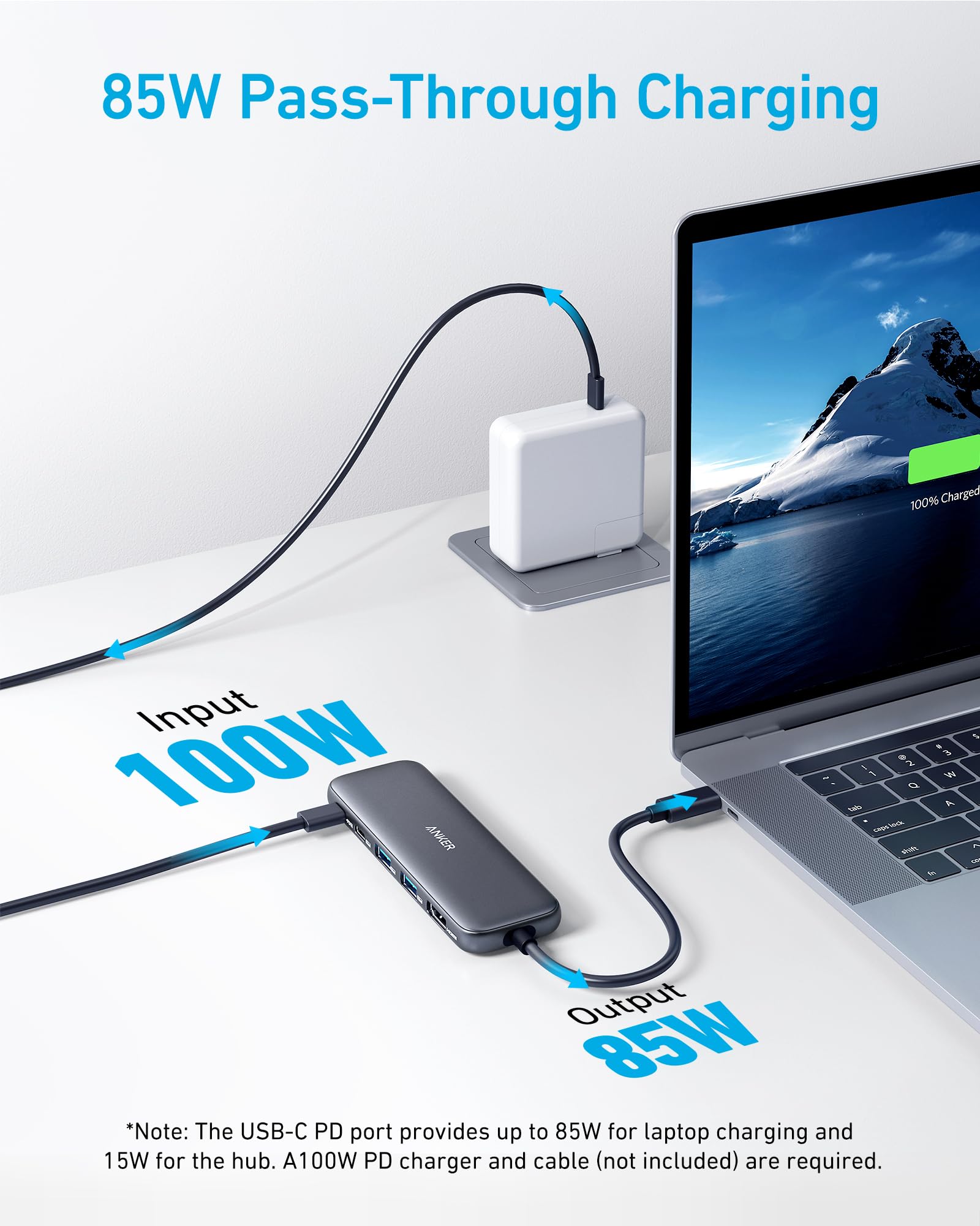 Laptop with USB-C hub and power adapter on a white surface, showcasing 85W pass-through charging.
