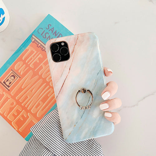 Five phone cases with marble patterns and ring holders on a white background