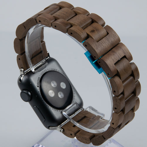 Smartwatch with a wooden band on a clear stand against a light gray background